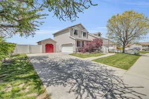 Front of property featuring a front lawn, a shed, and a garage