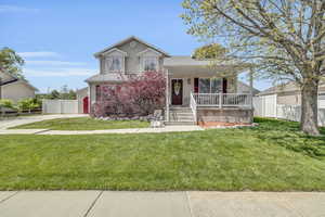 View of front facade featuring a front lawn and covered porch