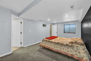 Bedroom with a textured ceiling and carpet floors