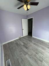 Spare room with ceiling fan and wood-type flooring