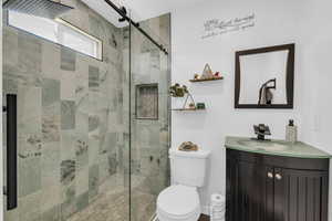 Bathroom with vanity, an enclosed shower, and toilet