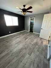 Unfurnished bedroom with connected bathroom, ceiling fan, hardwood / wood-style floors, and a textured ceiling