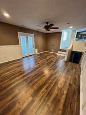 Unfurnished living room with ceiling fan and dark wood-type flooring