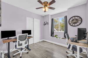 Office space with light hardwood / wood-style flooring and ceiling fan