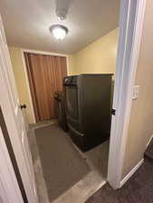 Clothes washing area with washing machine and dryer and a textured ceiling