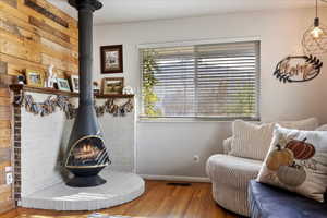 Living area featuring hardwood / wood-style flooring, a wood stove, and plenty of natural light