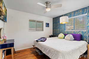 Bedroom featuring hardwood / wood-style flooring, ceiling fan, and multiple windows