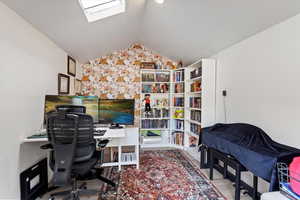 Office space with hardwood / wood-style flooring and lofted ceiling