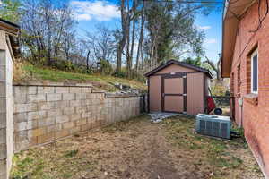 View of yard featuring central AC and a shed