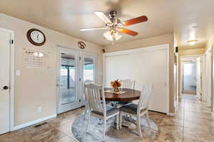 Dining room with ceiling fan and light tile patterned flooring