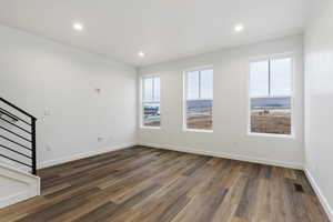 Unfurnished room with a wealth of natural light and dark wood-type flooring