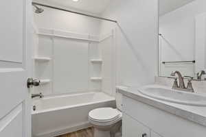 Full bathroom featuring vanity, toilet, wood-type flooring, and shower / tub combination