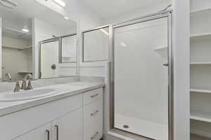 Bathroom with vanity and a shower with door