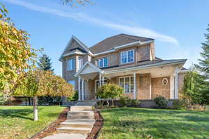 View of front of property with a porch and a front lawn