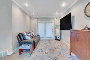 Primary Bedroom with ornamental molding and light carpet