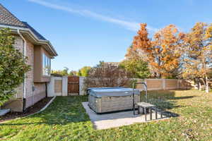 View of yard with a hot tub and a patio area