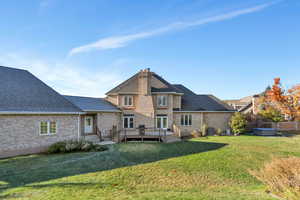 Back of house featuring a hot tub, a wooden deck, cooling unit, and a yard