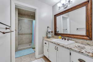 Bathroom featuring tile patterned flooring, vanity, and a shower with shower curtain