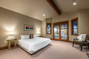 Bedroom featuring access to exterior, light carpet, and lofted ceiling with beams