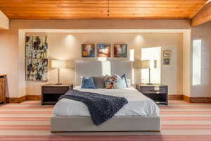 Bedroom featuring light carpet and wooden ceiling