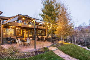 Yard at dusk featuring an outdoor living space, a balcony, and a patio