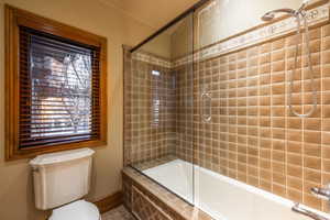 Bathroom with enclosed tub / shower combo and toilet