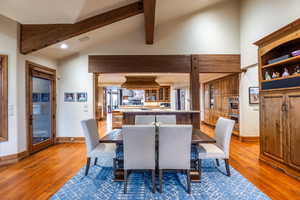 Dining room featuring lofted ceiling with beams and light hardwood / wood-style floors