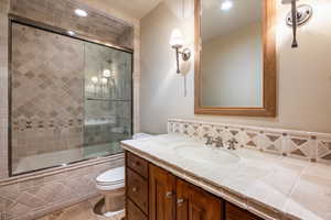 Full bathroom featuring tile patterned flooring, vanity, enclosed tub / shower combo, and toilet