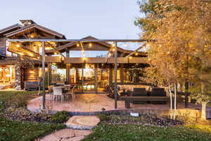 Back house at dusk featuring an outdoor hangout area and a patio area