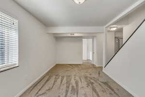 Basement featuring light carpet and plenty of natural light