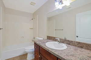 Full bathroom with tile patterned floors, vanity, shower / bathtub combination, and toilet