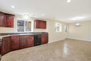 Kitchen featuring dishwasher, decorative light fixtures, plenty of natural light, and sink