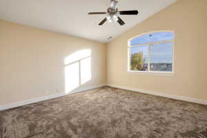 Empty room with carpet floors, ceiling fan, and lofted ceiling