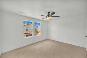 Carpeted empty room with ceiling fan