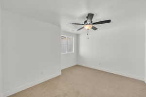 Spare room with ceiling fan and light carpet