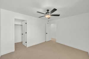 Unfurnished bedroom with a closet, ceiling fan, and light colored carpet