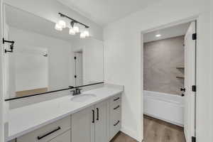 Bathroom featuring vanity, hardwood / wood-style floors, and tiled shower / bath