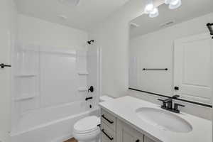 Full bathroom with bathtub / shower combination, vanity, and toilet