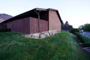 View of side of property with a lawn and a mountain view