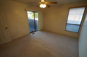 Carpeted empty room featuring ceiling fan