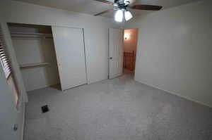 Unfurnished bedroom with a closet, light colored carpet, and ceiling fan