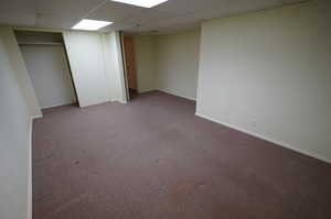 Basement with carpet flooring and a paneled ceiling