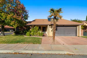 Single story home featuring a front yard and a garage