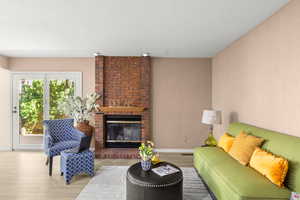 Living room featuring hardwood / wood-style flooring and a brick fireplace