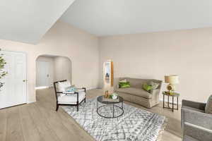 Living room with light hardwood / wood-style flooring and high vaulted ceiling