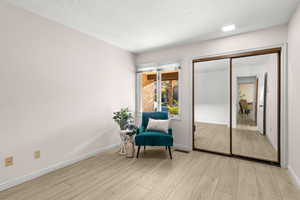 Living area featuring light hardwood / wood-style floors and a textured ceiling