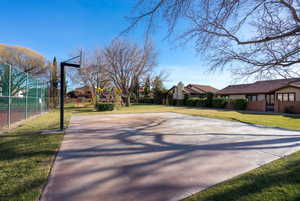 View of sport court featuring a yard