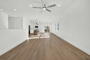 Unfurnished living room with light hardwood / wood-style floors, ceiling fan, and sink