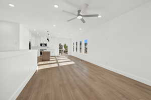 Unfurnished living room featuring light hardwood / wood-style flooring and ceiling fan