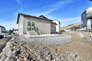 Rear view of property with a mountain view and a patio